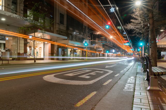 Long-exposure light trails on a Wellington street at night with a 30 speed limit marking on the road