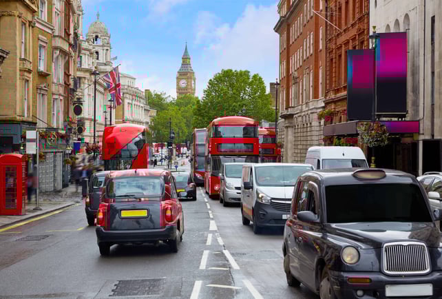 Red double-decker buses on a busy London street with Big Ben (Elizabeth Tower) in the background